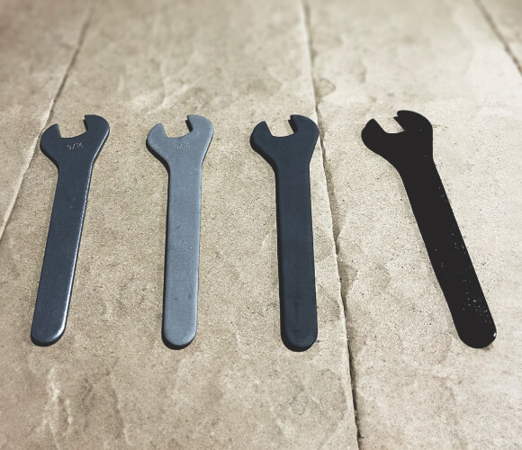 4 wrenches showing different states of ferritic nitrocarburizing and colors
